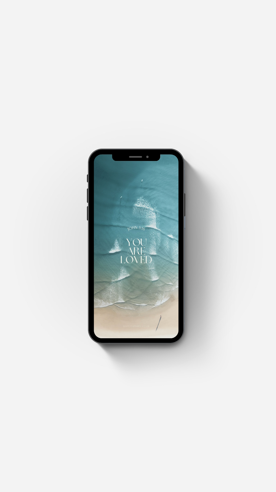 Smartphone displaying a beach scene with 'You Are Loved' text on a white background Bible Verse Wallpaper by Stay Lit Apparel