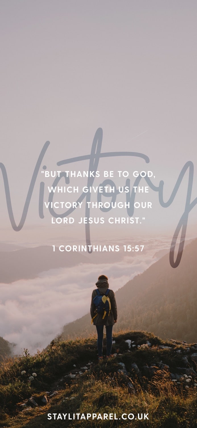 Person standing on a mountain with a quote about victory from 1 Corinthians 15:57, with 'StaylitApparel.co.uk' branding.
