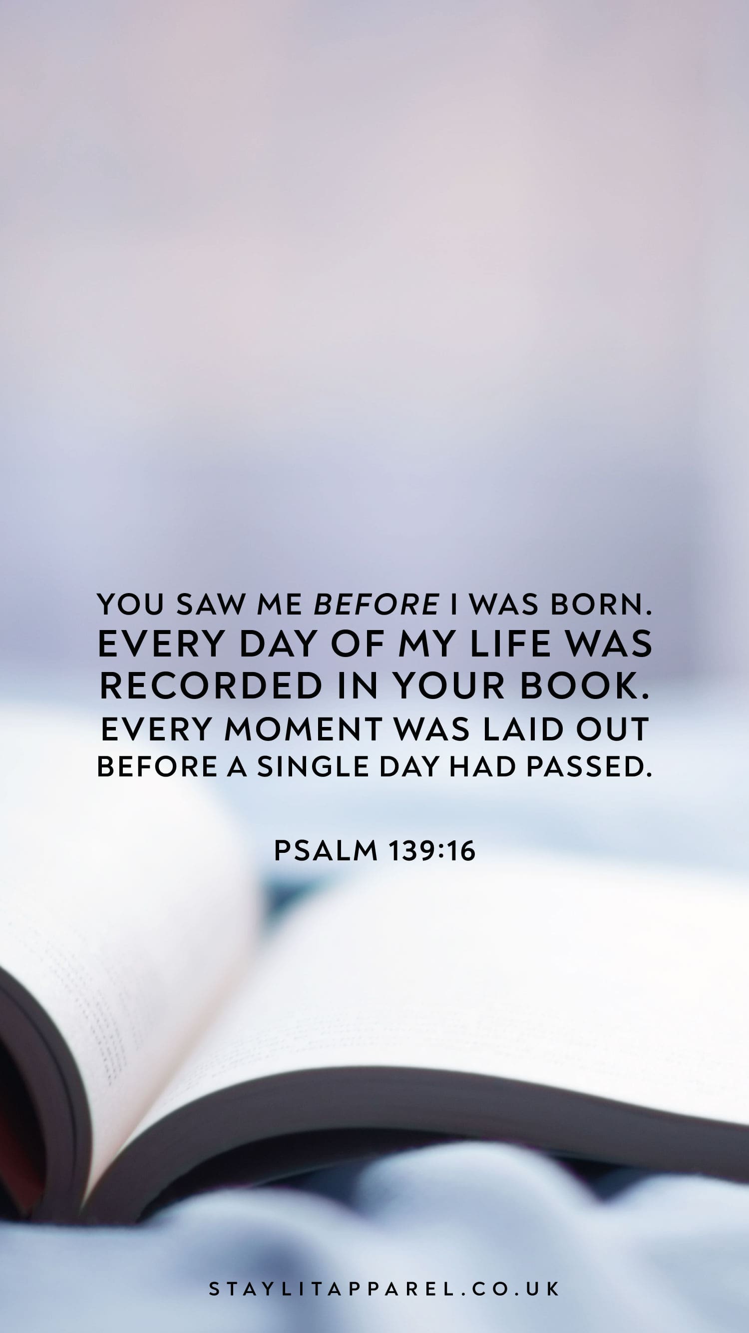 Open book with a quote from Psalm 139:16 on a blurred background.