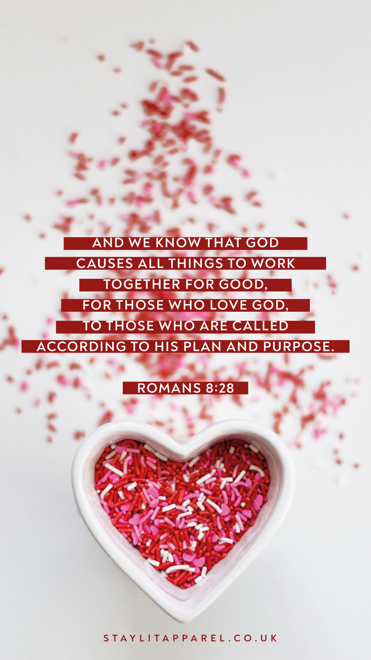 Heart-shaped bowl with red heart-shaped candies and Romans 8:28 text on a white background.